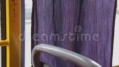 紫丁香的窗帘在公共汽车的玻璃附近晃动。 紫色的<strong>帷幕</strong>飘扬
